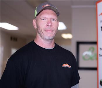 production tech male in a SERVPRO hat and a black SERVPRO t-shirt