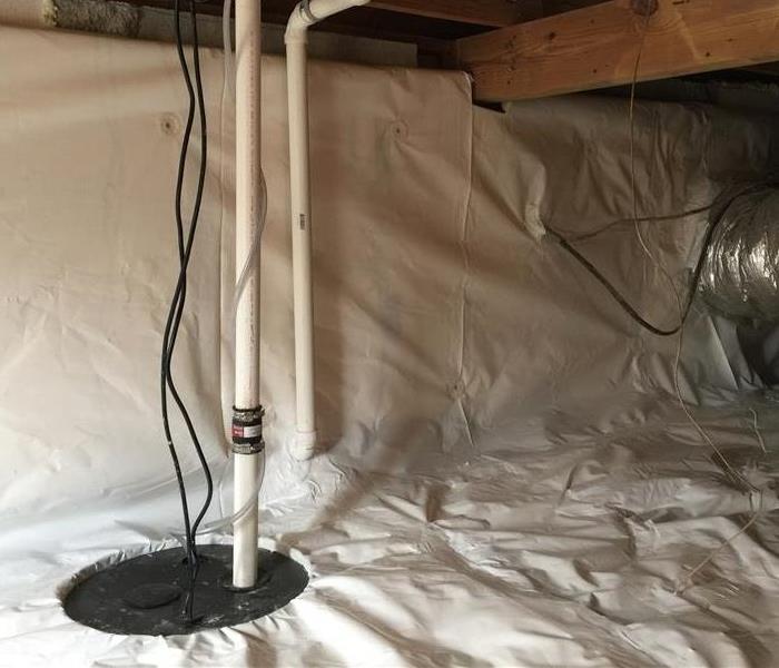 a cleaned and encapsulated crawlspace that has a visible sump pump