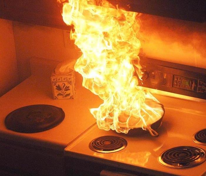 skillet on an oven in flames