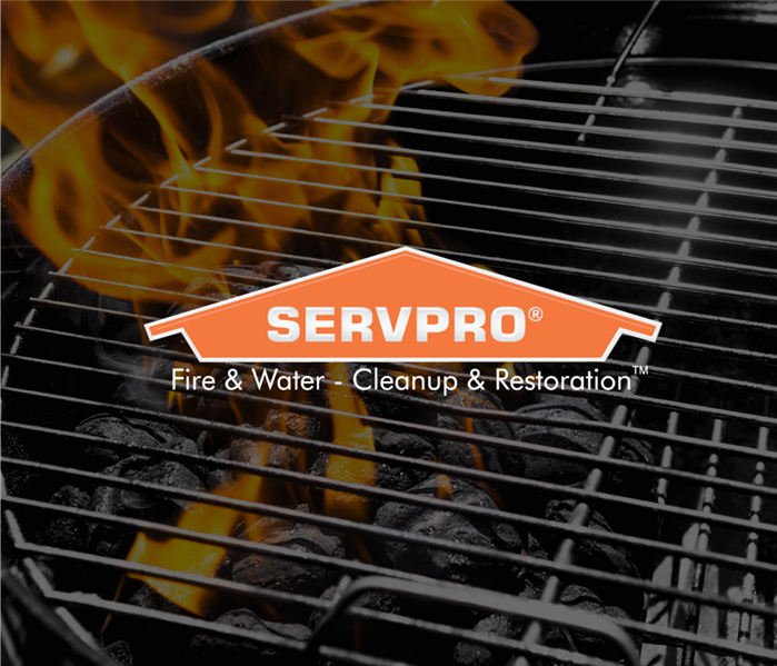 Grill with coals on fire with the Servpro logo over top